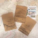 Back of three kraft notebooks with illustrations of towns and villages on vintage maps. 