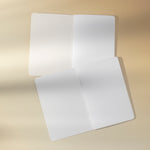 Two open notebooks with blank white pages on a beige background.