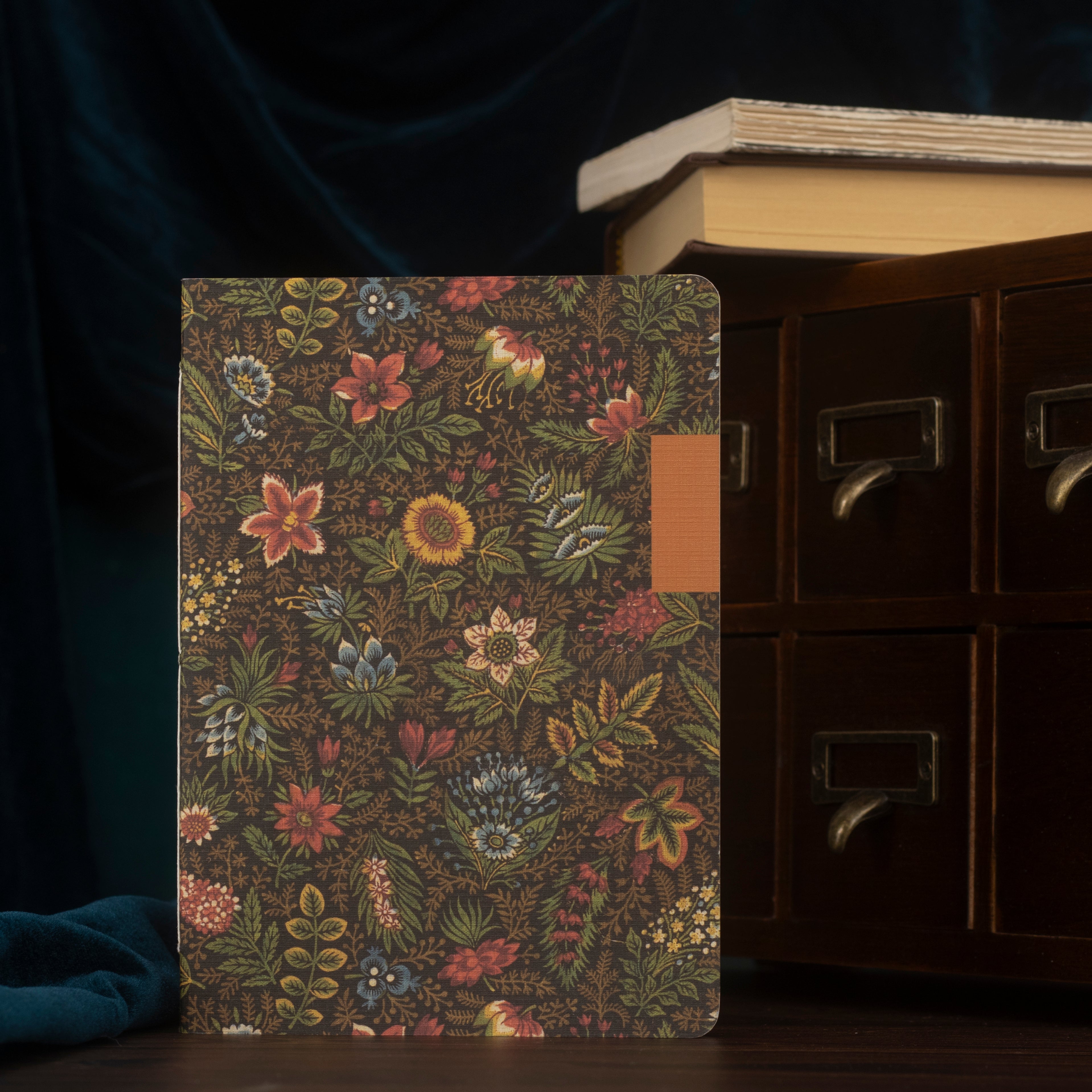 Front of a floral-patterned notebook with a dark background.
