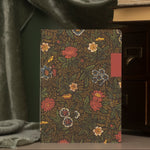 Front side of a floral-patterned notebook  on a green background.