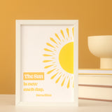 Framed print with a yellow sun illustration and text on a mustard yellow background. 
