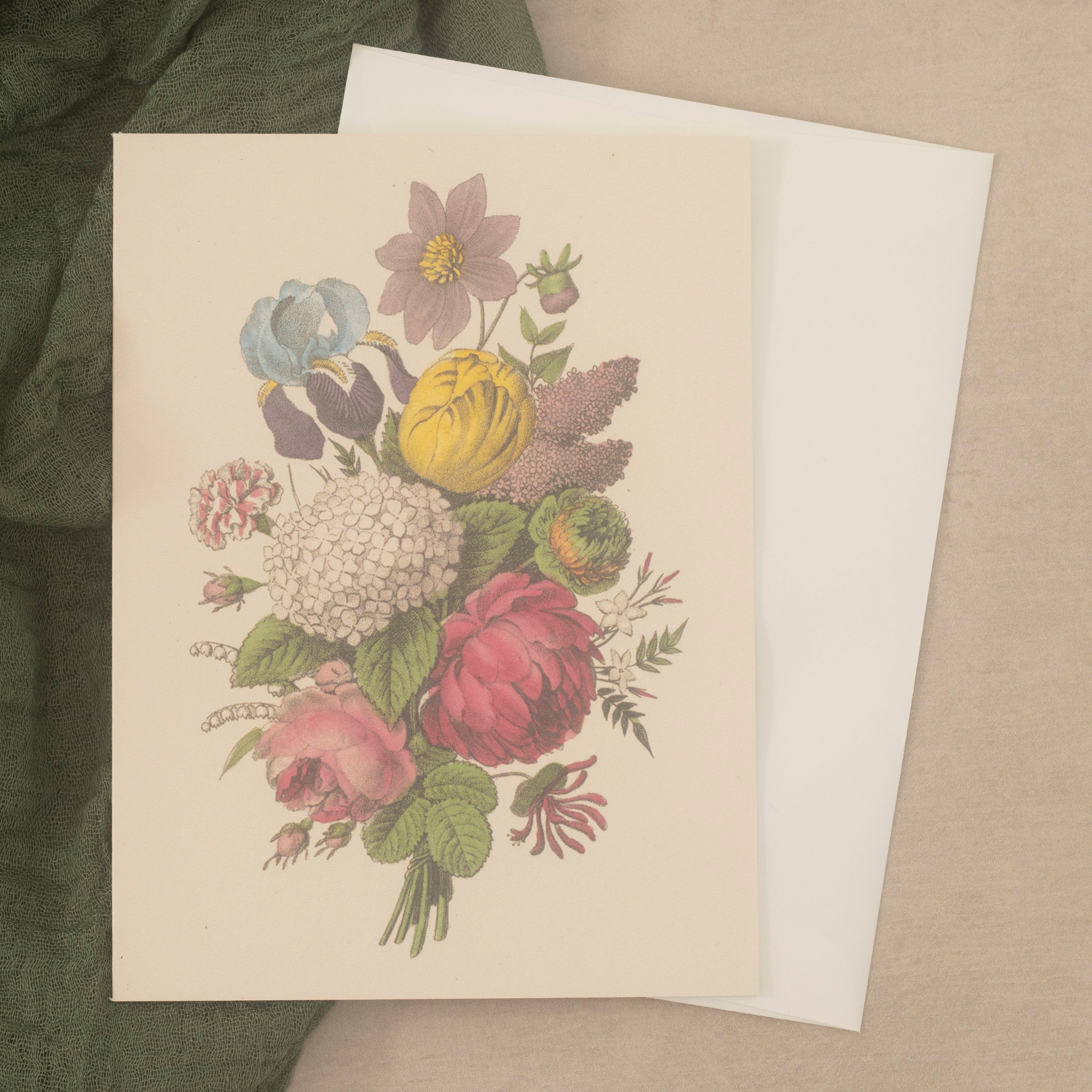 A card featuring a vintage image of a colorful bouquet of flowers, paired with an off-white envelope on a neutral beige surface.